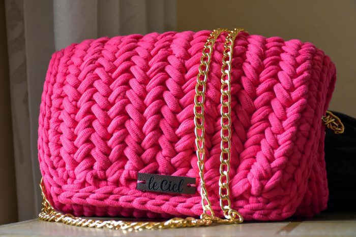 Deep pink handmade handbag with a unique texture and intricate detailing, perfect for accessorizing any outfit.