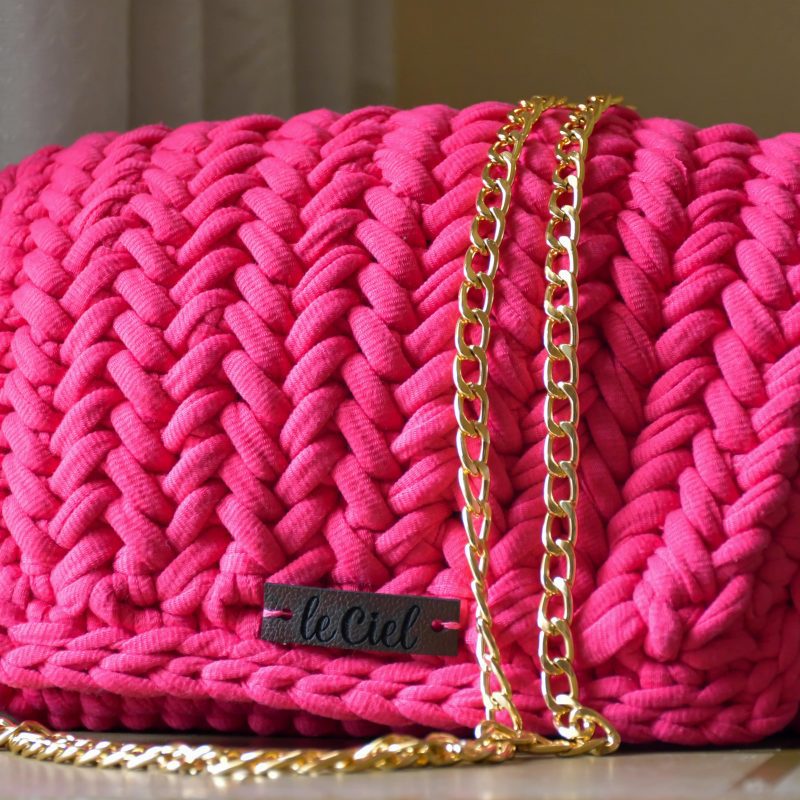 Deep pink handmade handbag with a unique texture and intricate detailing, perfect for accessorizing any outfit.
