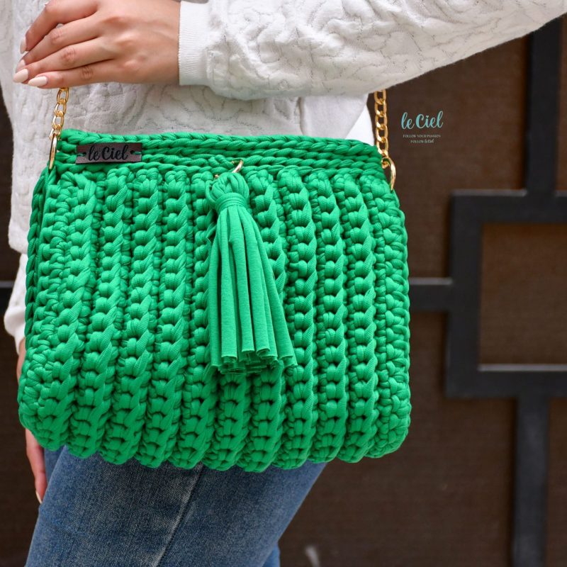 A stylish handbag in a beautiful shade of green. The bag features a sturdy strap and a roomy main compartment, perfect for holding all your essentials. The exterior is made from high-quality leather with a textured finish, adding a touch of sophistication to the design. With its clean lines and modern look, this handbag is a versatile accessory that can be dressed up or down.